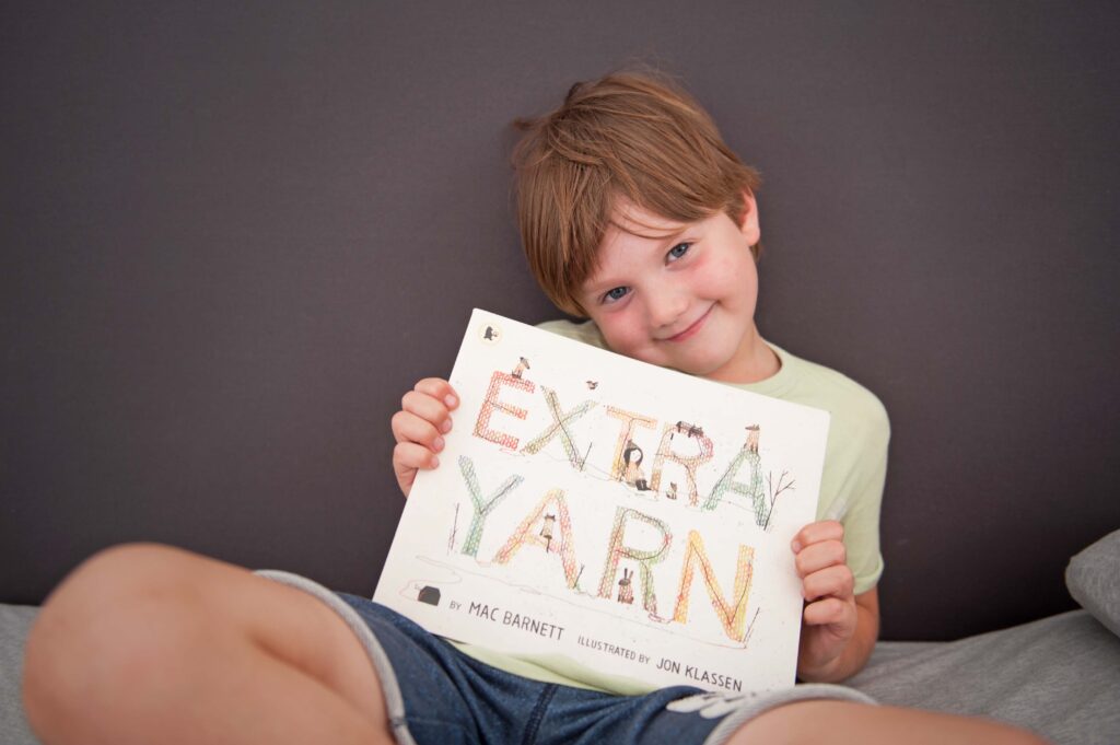 Child with picture book by Mac Barnett